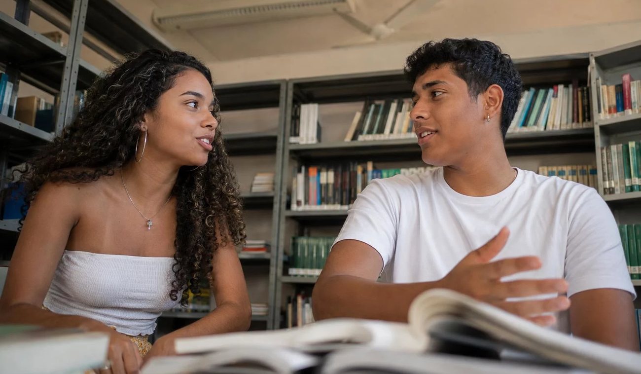 Pessoas conversando de pé junto às estantes antes de o encontro abrir
